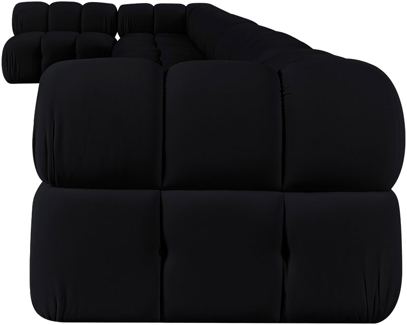 Black velvet L-shaped sectional sofa, close-up of tufted back cushions