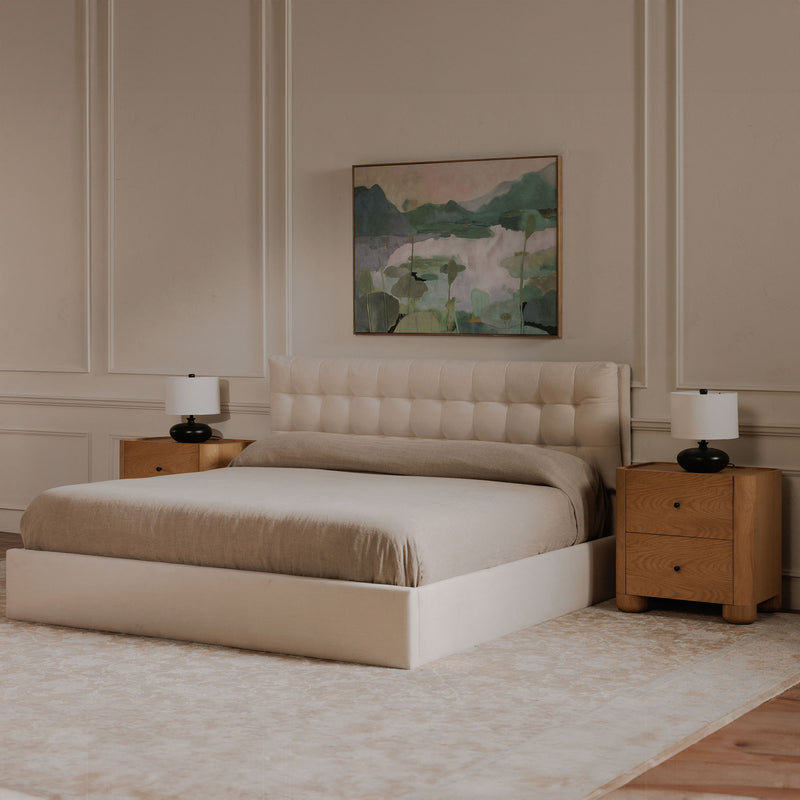 Cream upholstered king bed with tufted headboard, matching storage footboard, side view