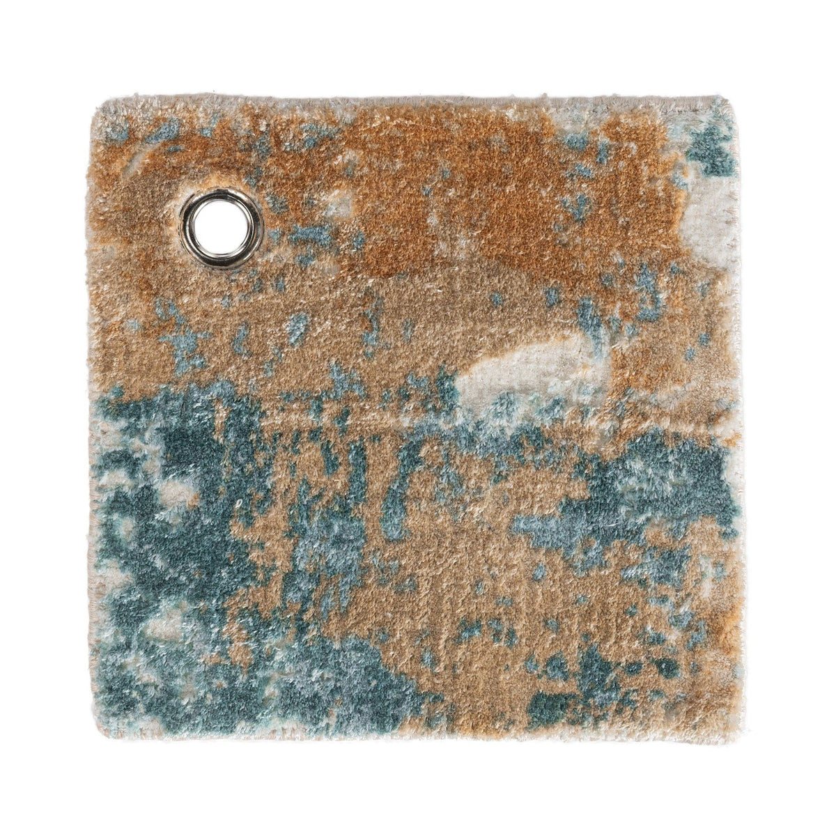 Distressed rug corner close-up with round grommet hole; blue, tan, and rust tones