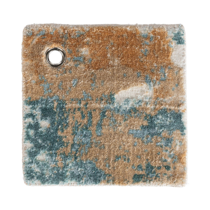 Distressed rug corner close-up with round grommet hole; blue, tan, and rust tones