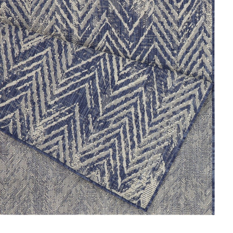 Indoor/outdoor area rug close-up: blue and cream chevron texture with soft pile.