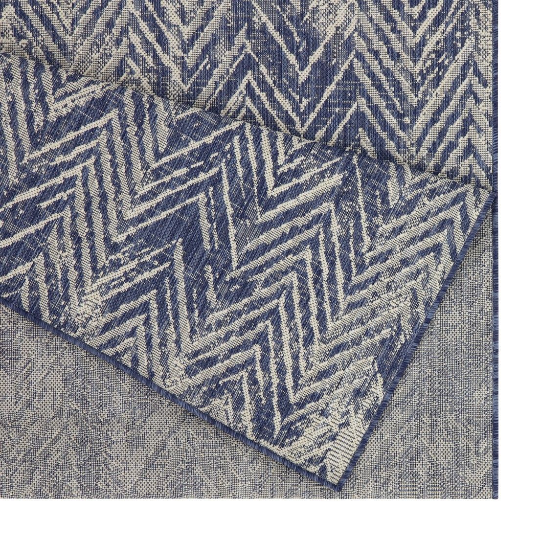 Blue indoor/outdoor area rug close-up with white zigzag chevron pattern.
