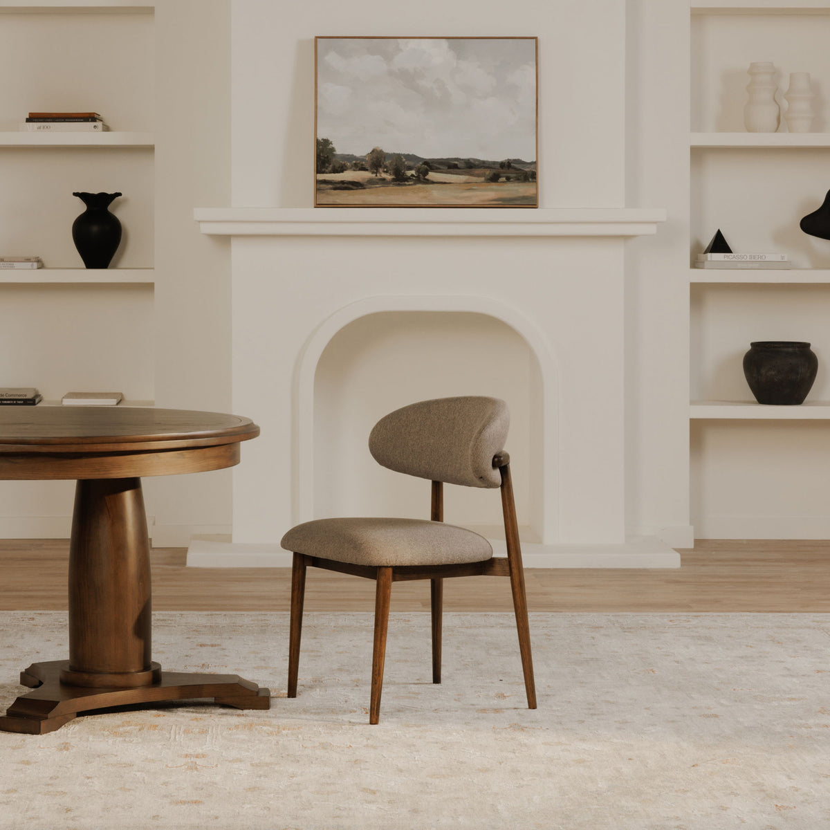 Upholstered dining chair with gray seat and rounded back, light wood frame