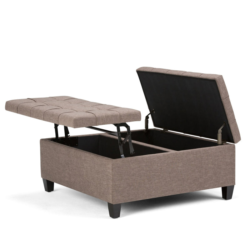 Beige fabric storage ottoman with hinged lid open, tufted top cushions, and legs