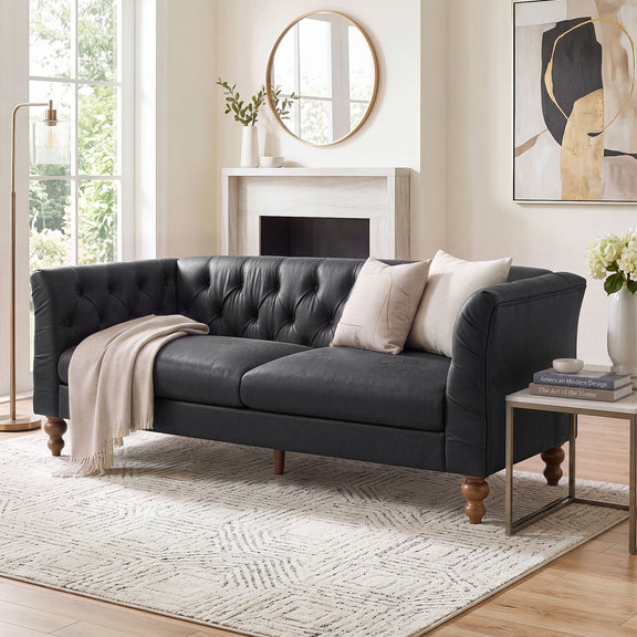 Black chesterfield-style sofa with tufted back, flared arms, and wooden legs