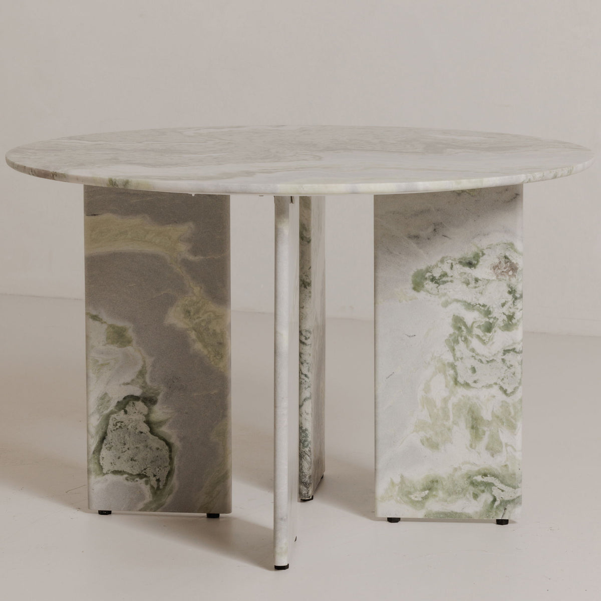 Round dining table with green veined marble top and white metal pedestal legs