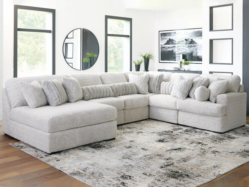 White sectional sofa with chaise corner and multiple throw pillows on plush cushions