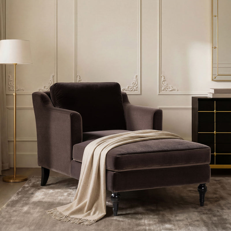 Dark brown upholstered chaise lounge with rounded arms, turned feet, and draped throw