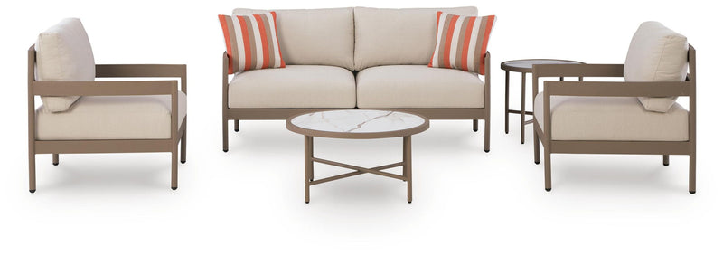 Beige patio loveseat with two lounge chairs and round coffee table