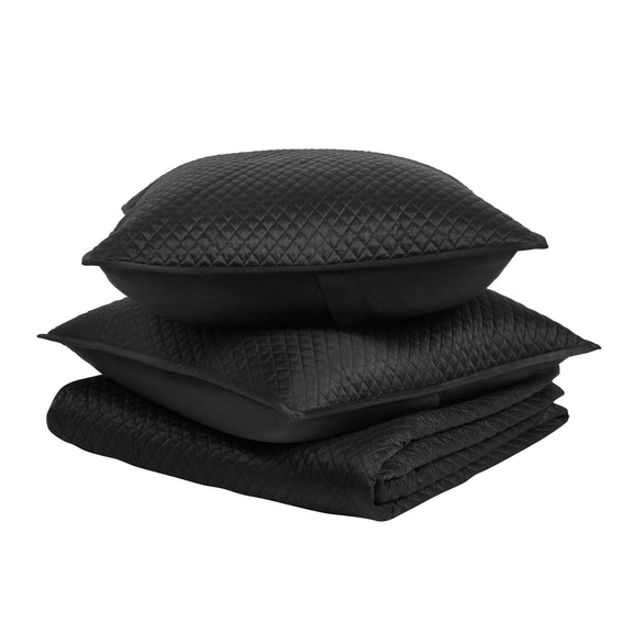 Diamond quilt set in onyx black: folded quilt with stacked textured shams