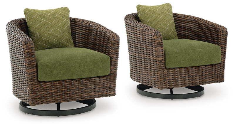 Pair of dark brown wicker swivel lounge chairs with green seat and back cushions