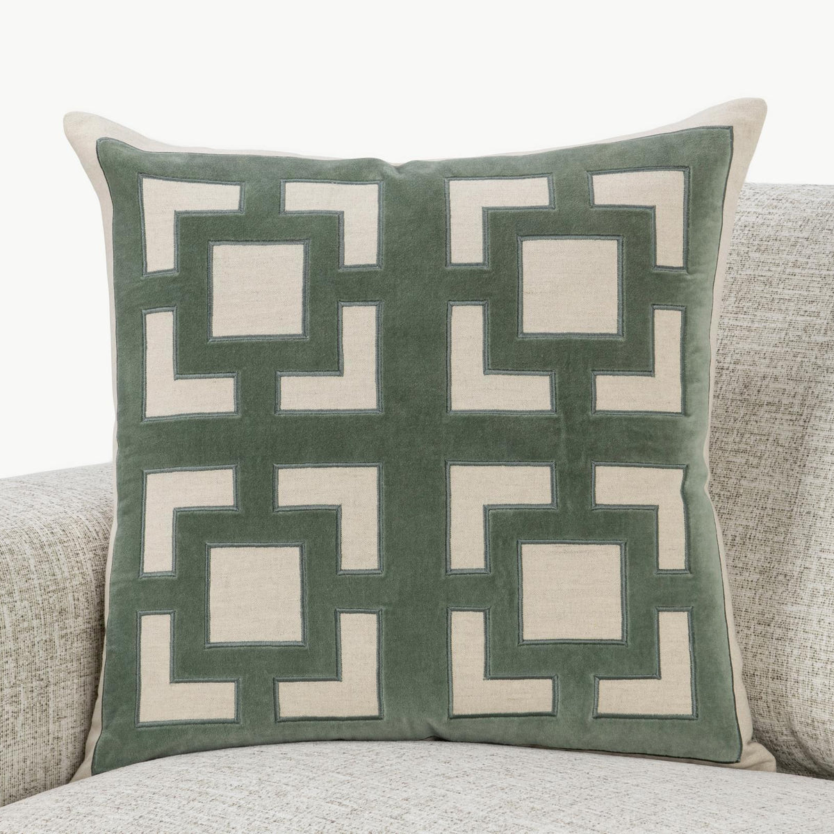 Teal-green geometric throw pillow with white inset squares and thick border outline.