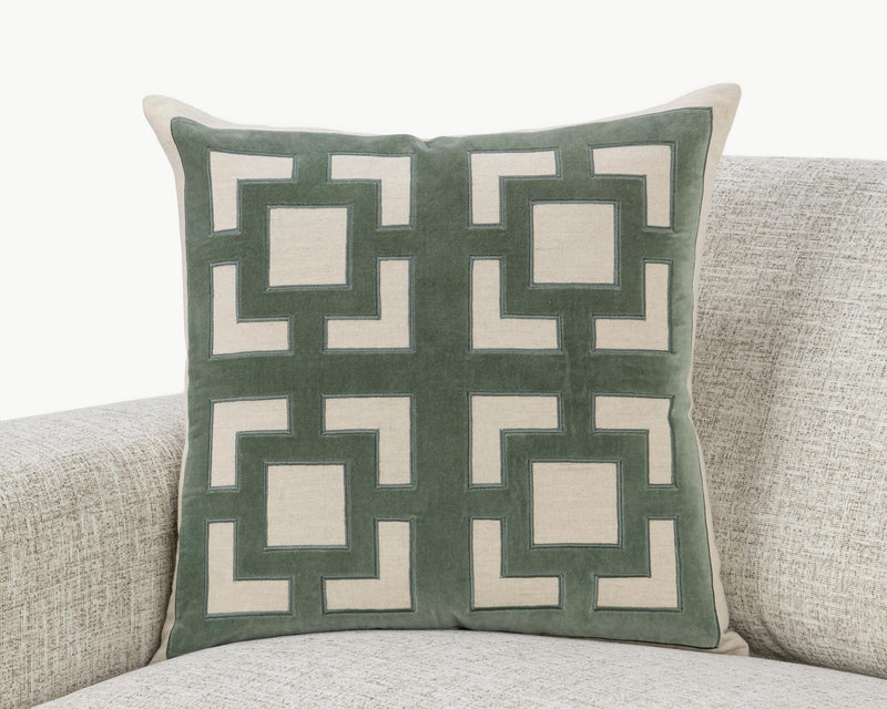 Teal-green geometric throw pillow with white inset squares and thick border outline.
