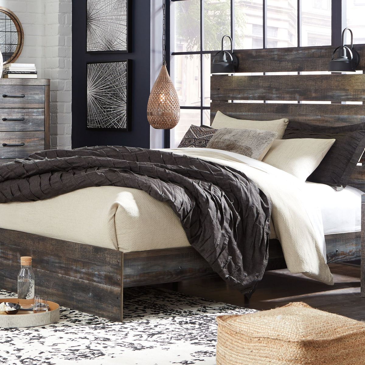 Drystan panel bed with dark wood frame and slatted headboard, styled with layered bedding