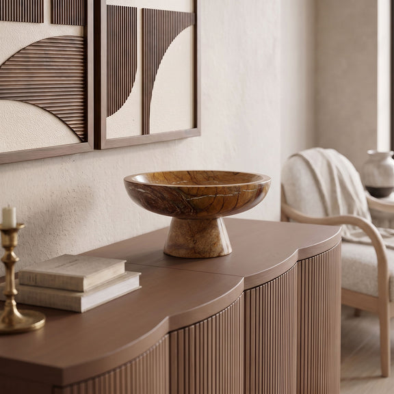 Brown marble pedestal bowl on a console table with carved marbling texture