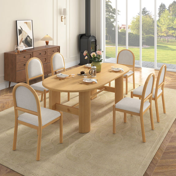 Light brown oval dining table with six upholstered chairs, side view, fabric seats