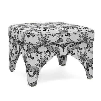 Upholstered ottoman in white with black jungle animal print, round padded top, short turned legs