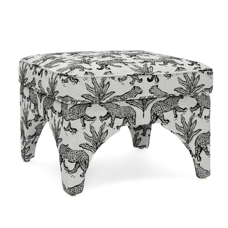 Upholstered ottoman in white with black jungle animal print, round padded top, short turned legs
