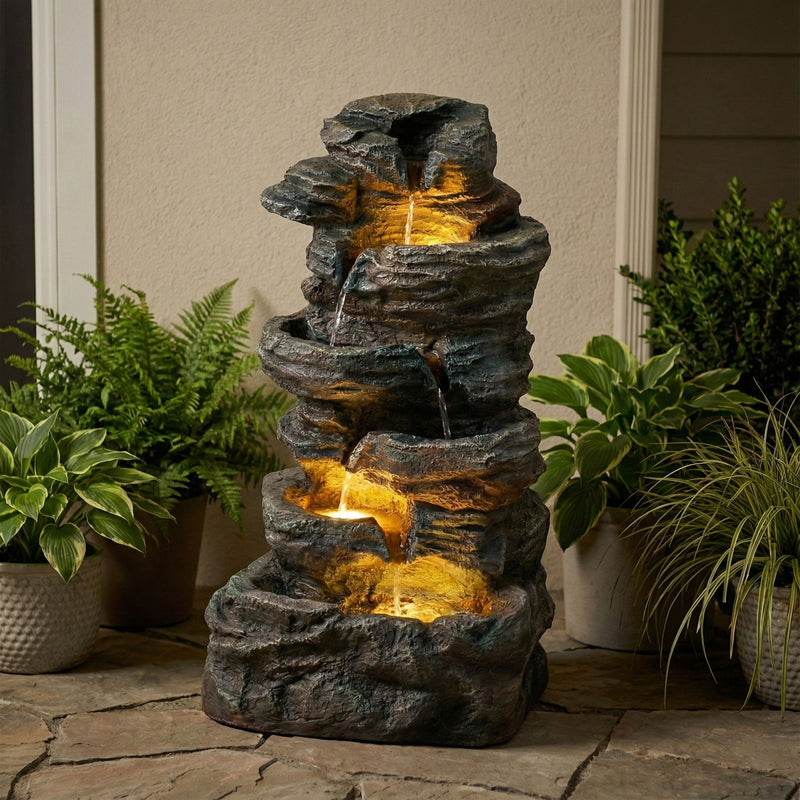 Gray tiered stone water fountain with warm LED glow and cascading water