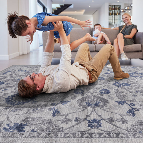 Light gray oriental area rug with blue floral motifs on a living room floor