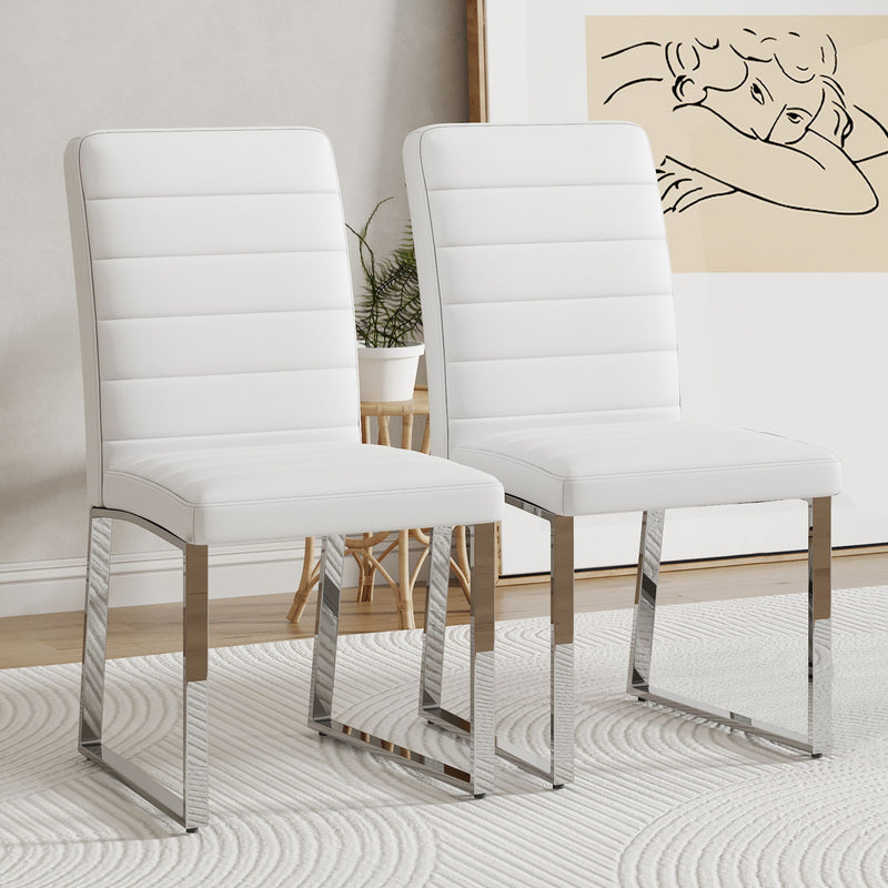 Two white upholstered dining chairs with curved backrests and padded seats