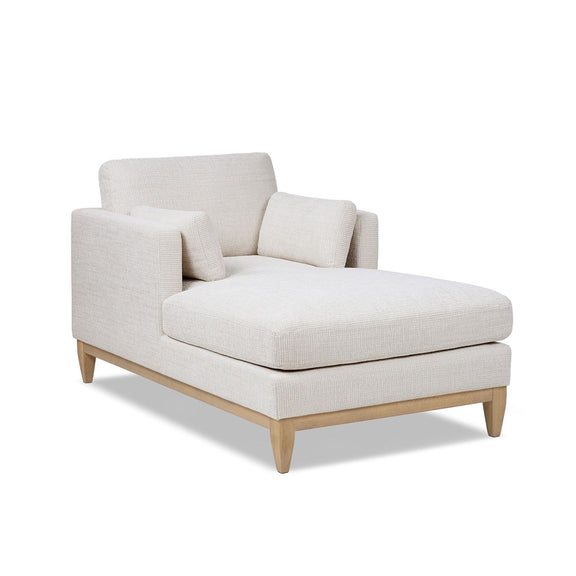 Beige fabric chaise lounge chair with padded back and ottoman-style base