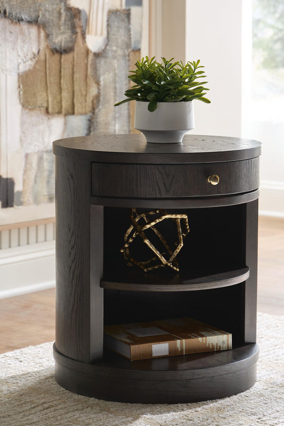 Dark brown round accent table with open middle shelf and drawer front with brass knob