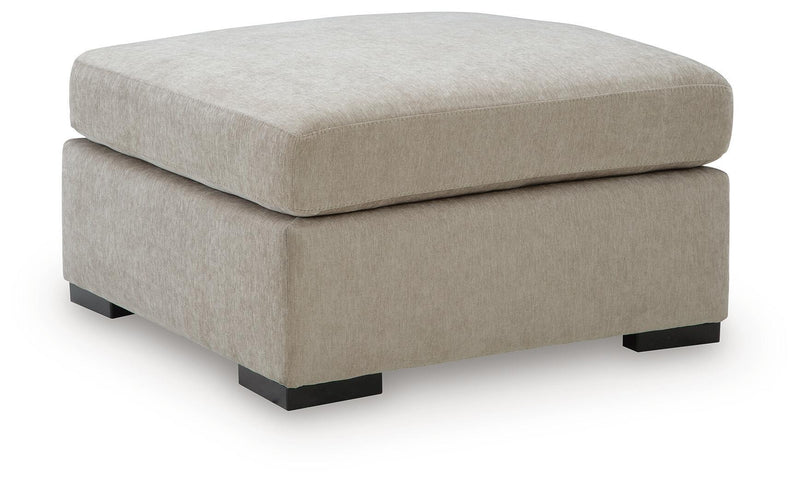 Oversized accent ottoman in light neutral fabric with black feet