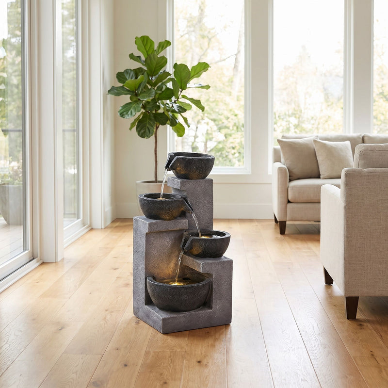 Gray four-tier water fountain with water cascading between bowls.