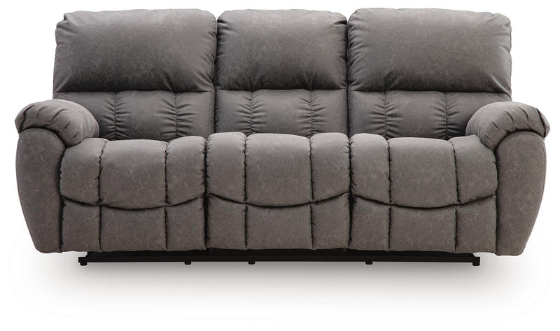 Dark gray reclining sofa with thick padded back cushions, tufted arms, adjustable headrests