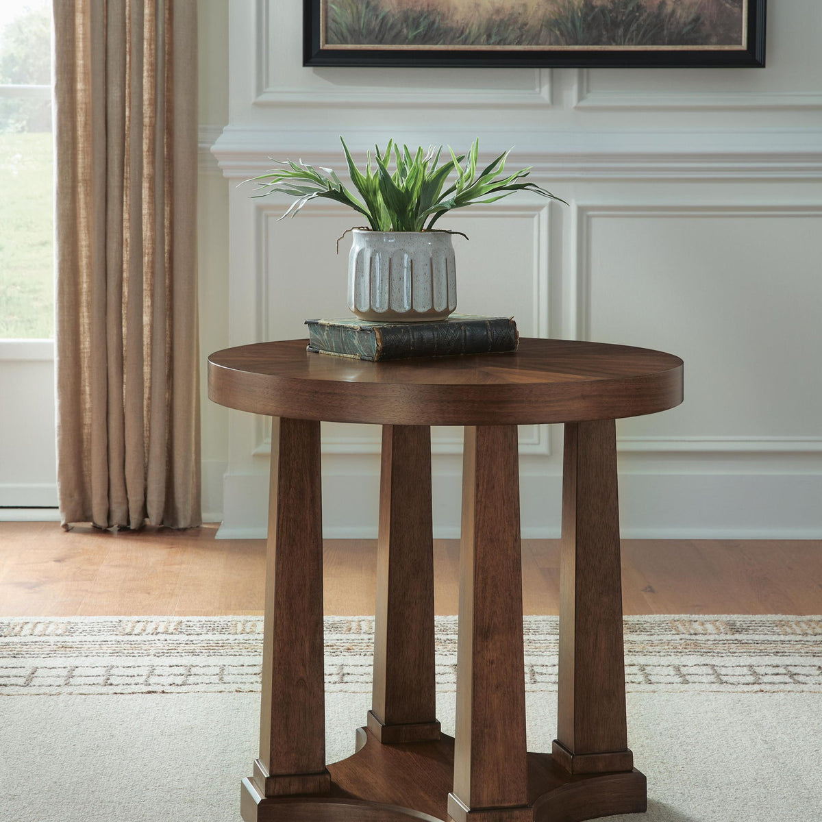 Round wooden side table with pedestal legs and built-in lower shelf