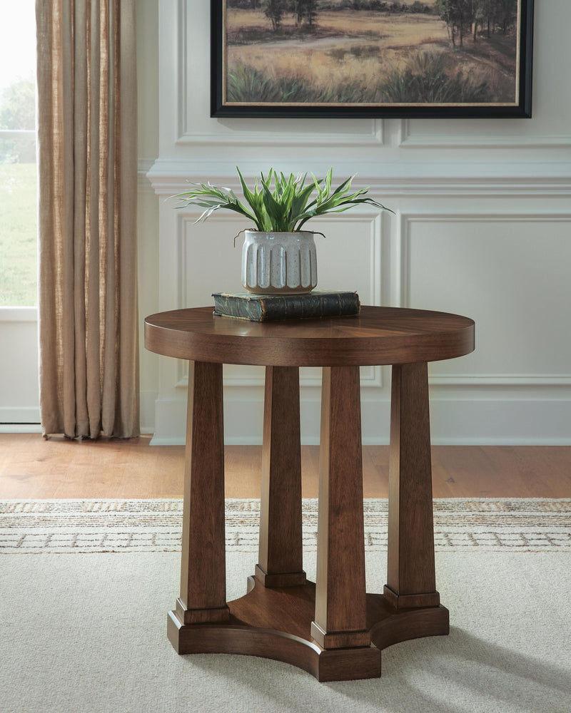 Round wooden side table with pedestal legs and built-in lower shelf