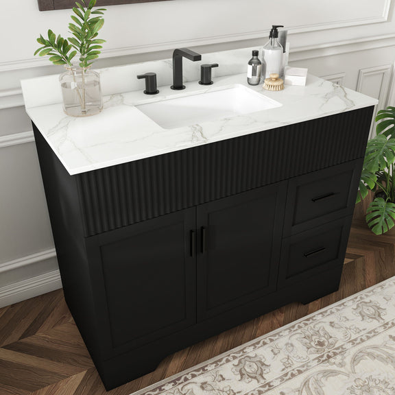 Black bathroom vanity with fluted doors, white countertop sink, three faucet holes