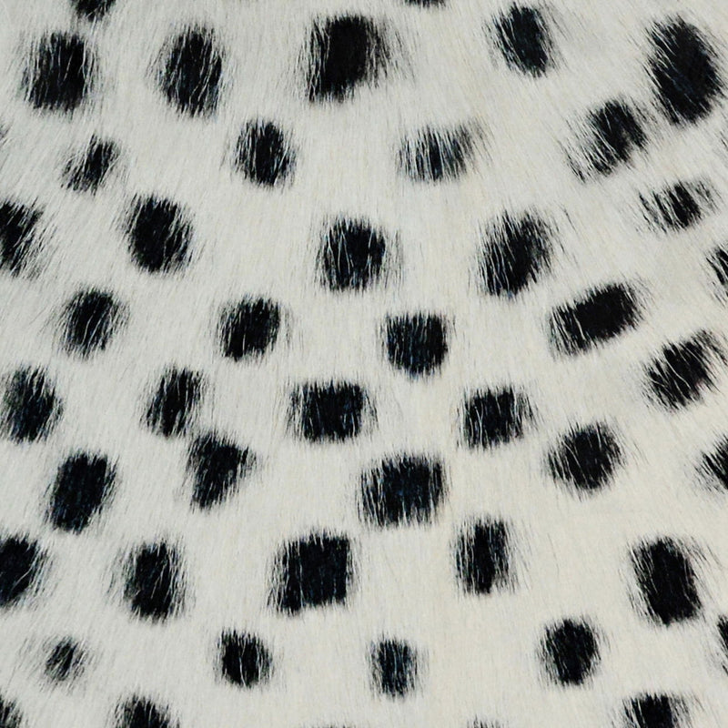 White fur pillow fabric with black dot pattern, close-up texture