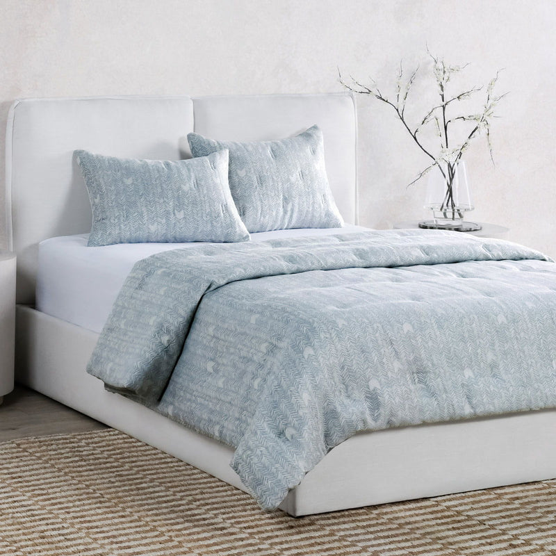 Storm blue comforter with herringbone weave and matching pillow shams on bed