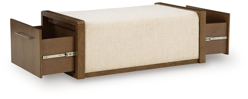 Brown storage ottoman showing open side compartments and beige upholstered top