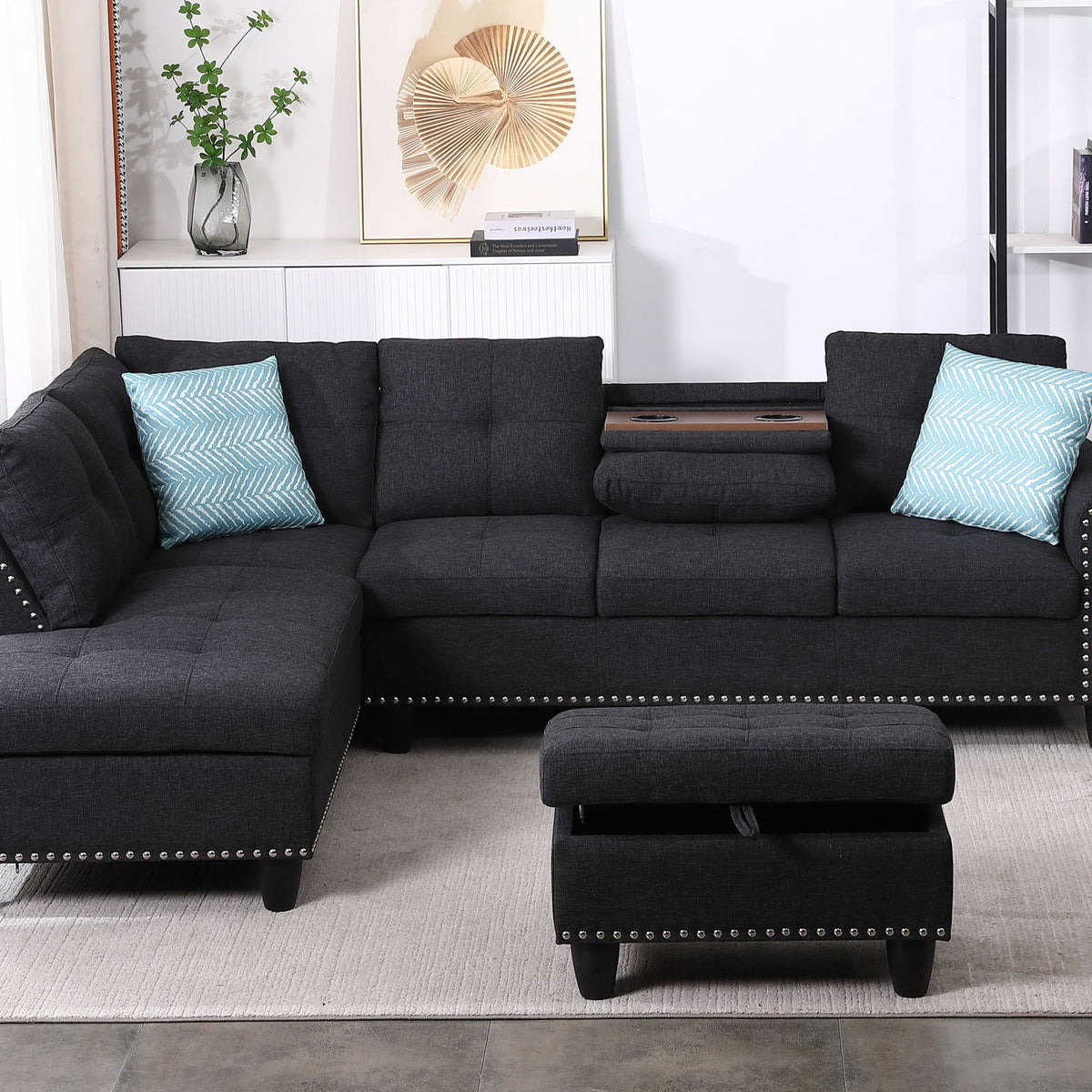 Dark gray sectional sofa with left-facing chaise and ottoman, blue accent pillows