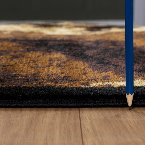 Southwest area rug close-up showing low pile and black binding, leopard pattern in tan.