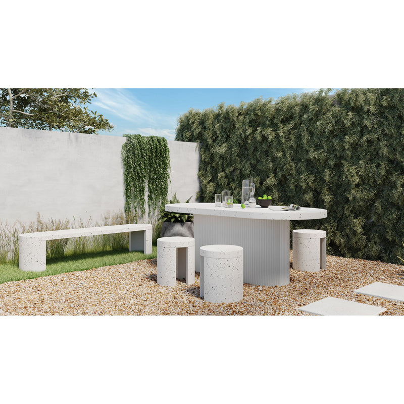 Round outdoor dining table with speckled surface and fluted pedestal base