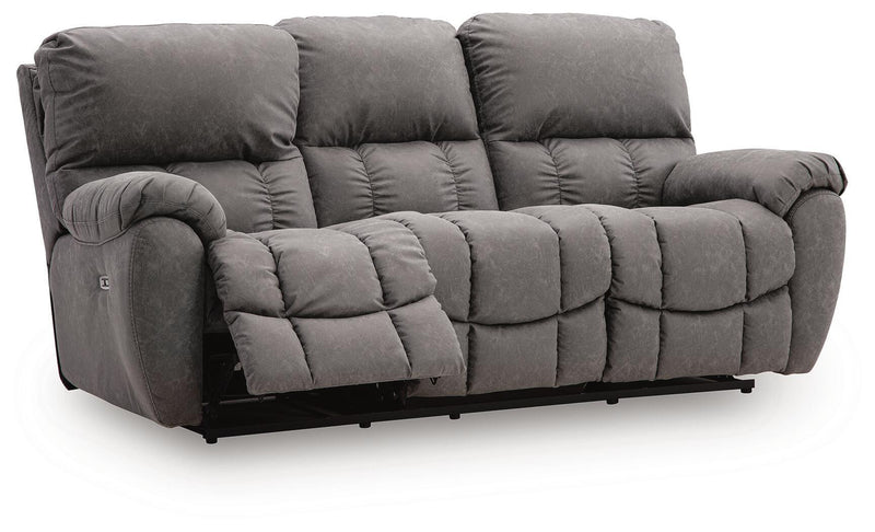 Dark gray power reclining sofa with adjustable headrest and cushioned armrests, tufted
