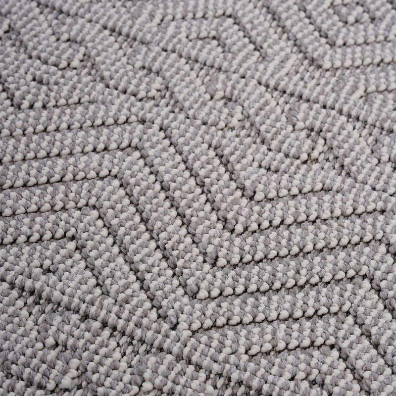 Geometric rug surface in textured dark gray and light gray with repeating diamond motif