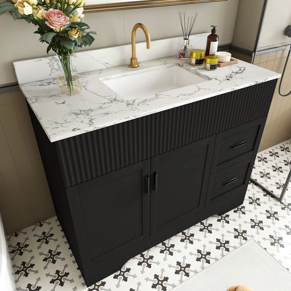 Black bathroom vanity with fluted cabinet front, white marble-look countertop and sink