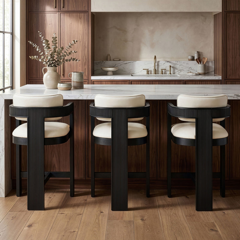 Set of 3 vegan leather counter stools with tan upholstered seats and black ribbed bases