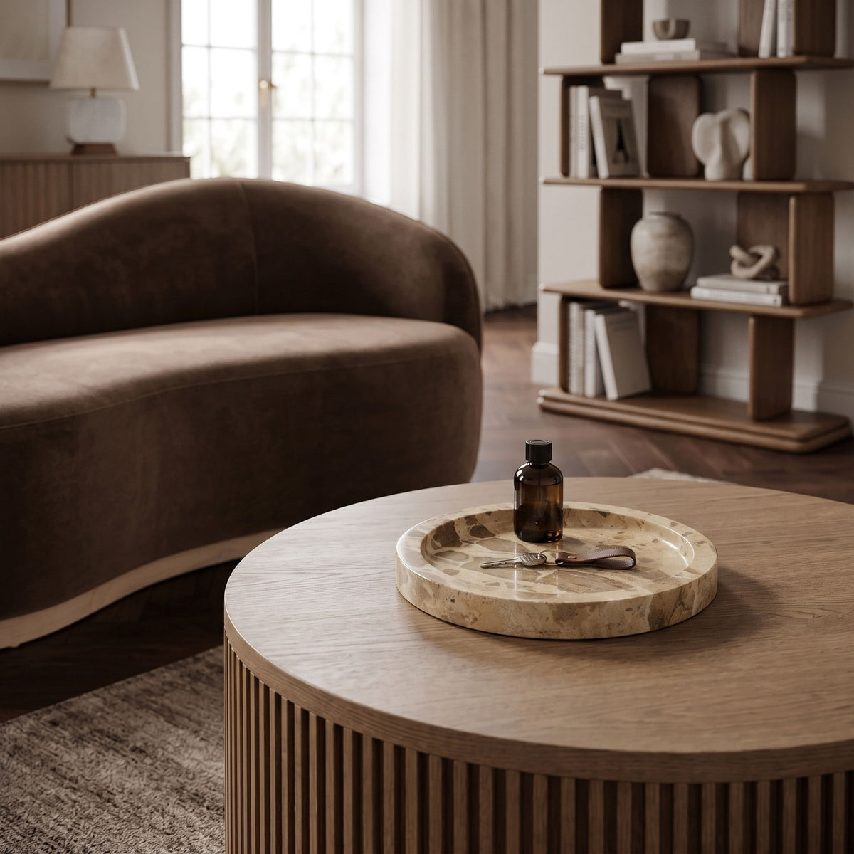 Round beige marble tray on table with shallow basin and stone veining
