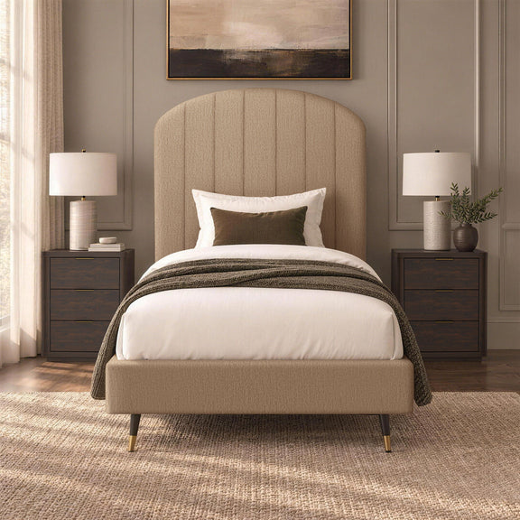 Beige upholstered bed with arched channel headboard, white bedding, and throw blanket