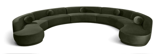 Forest green velvet sectional sofa with rounded, button-tufted seat cushions.
