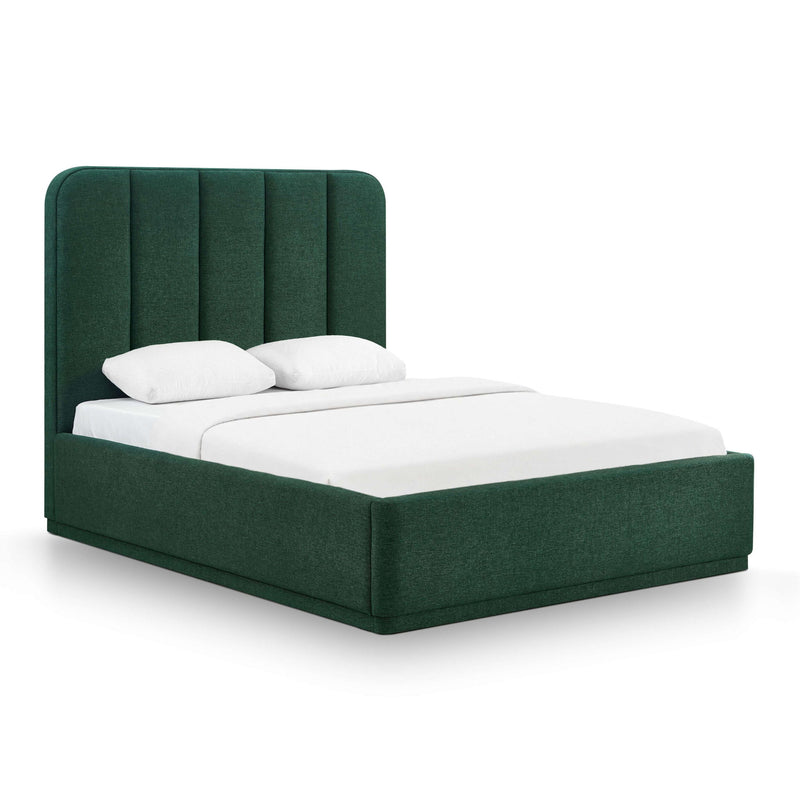 Dark green upholstered bed with tall headboard, white fitted mattress, and two pillows.