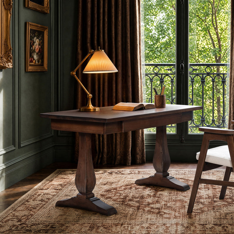 Brown writing desk with turned pedestal legs and flat rectangular top.