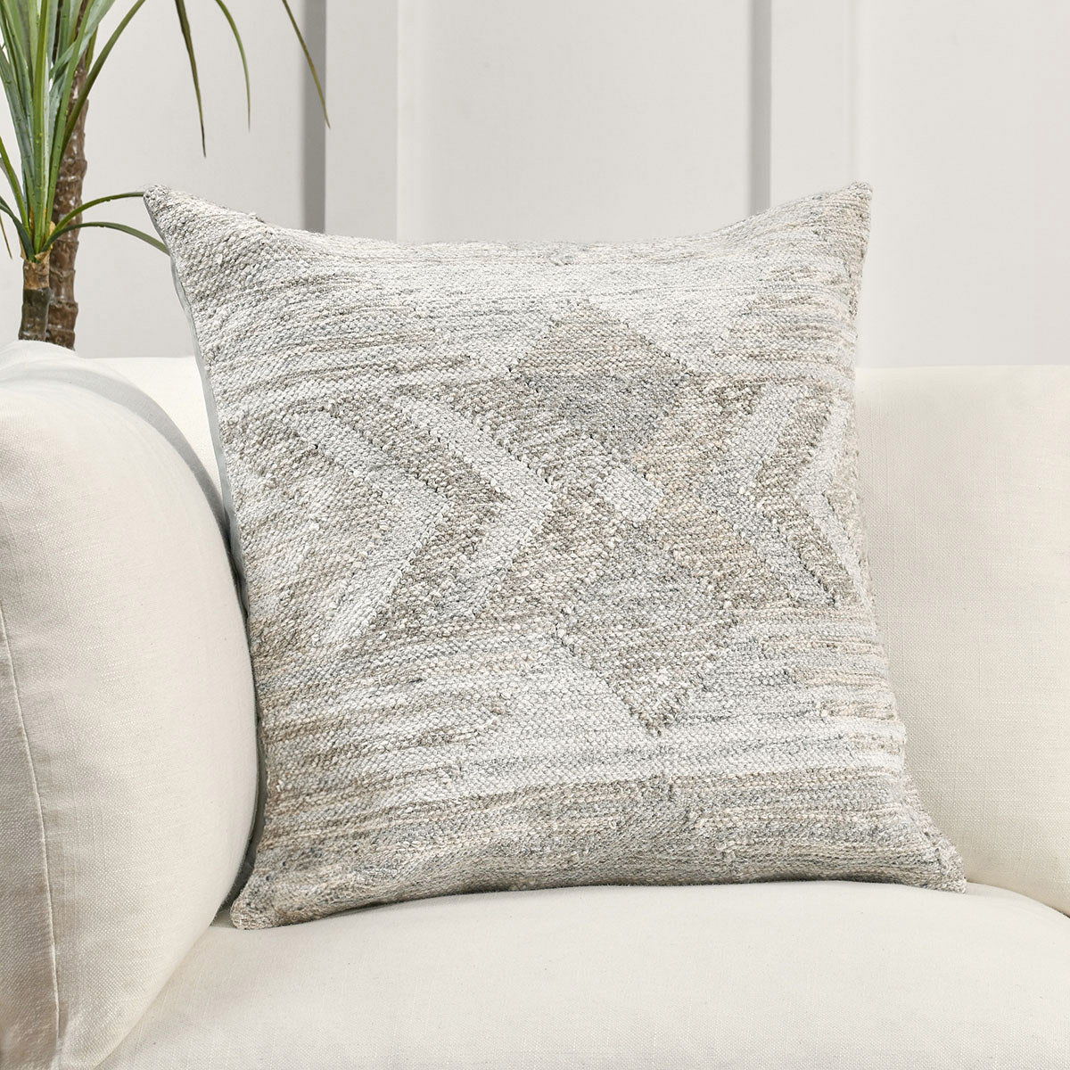 Gray multi woven decorative pillow with geometric pattern on sofa seat