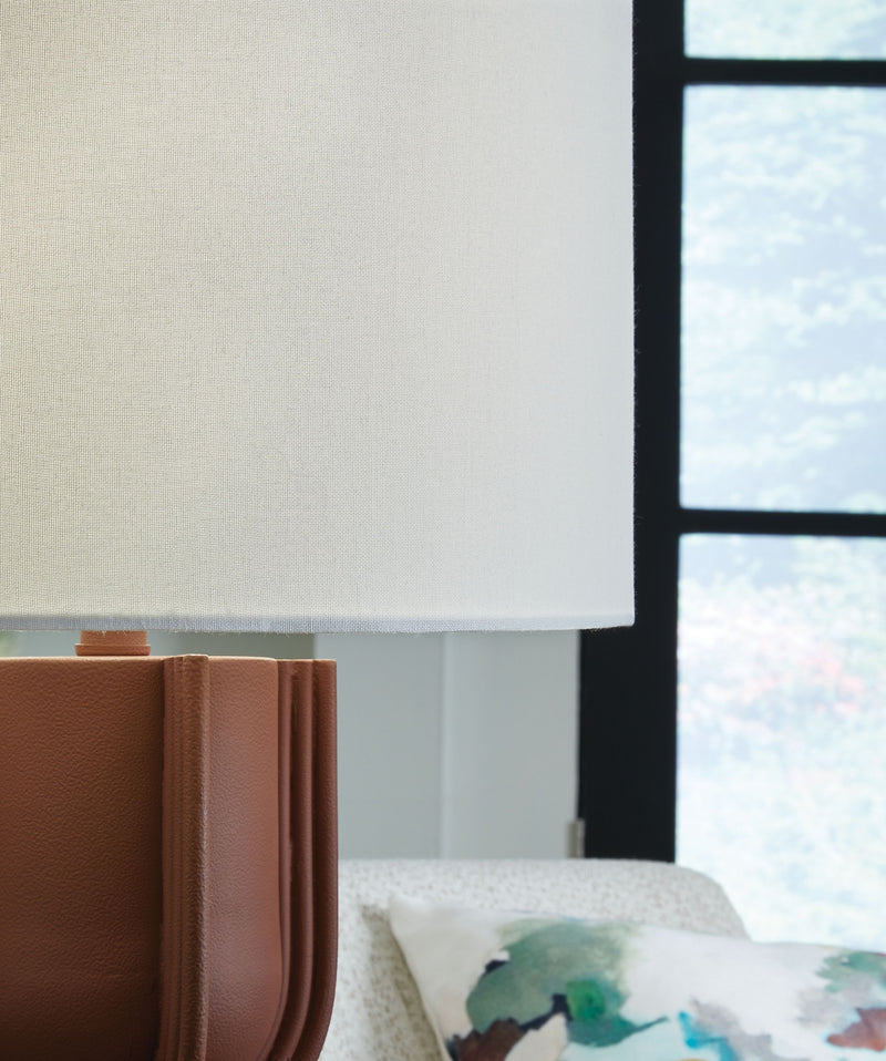 Brick red metal lamp base with ribbed texture and white drum shade edge